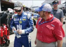  ?? STEVE HELBER — THE ASSOCIATED PRESS ?? Dale Earnhardt Jr., left, signs autographs for fans after practice for Sunday’s NASCAR Cup Series auto race at Richmond Internatio­nal Raceway in Richmond, Va., Saturday.