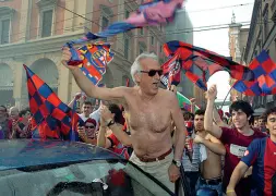  ??  ?? Rossoblù Un Berselli entusiasta in piazza a torso nudo festeggia il ritorno del Bologna in serie A