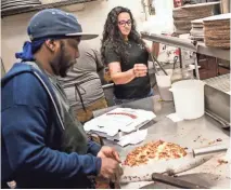  ??  ?? Dewana Ishee, right, helps in the kitchen as Will Rose cuts a pizza at Broadway Pizza’s original location on Broad Avenue. PHOTOS BY BRAD VEST/THE COMMERCIAL APPEAL