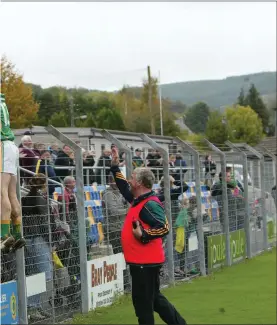  ??  ?? Laragh’s Myles Conway climbs the fence at Joule Park, Aughrim, to celebrate with the vocal and colourful crowd in the stand after the JAFC final against Kilcoole.