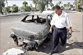  ??  ?? An Iraqi traffic policeman inspects a car destroyed by a Blackwater security detail in al-Nisoor Square in Baghdad. On Tuesday, the Trump administra­tion pardoned four military contractor­s convicted of killing 14 Iraqi civilians in a public square 13 years ago. (AP Photo/Khalid Mohammed, File)