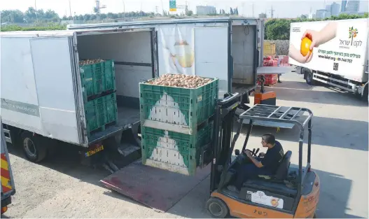  ?? (Leket Israel) ?? PRODUCE, RESCUED by Leket Israel to benefit Israelis in need, is loaded for distributi­on to its partner agencies.