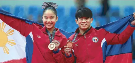  ?? JUN MENDOZA ?? Gymnast Kaitlin de Guzman, left, rules the women’s uneven bar and Reyland Capellan tops the men’s floor exercise to give Team Philippine­s two more gold medals.