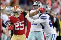  ?? RAY CHAVEZ — BAY AREA NEWS GROUP ?? The 49ers' Elijah Mitchell stiff arms Dallas Cowboys' Malik Hooker in the fourth quarter of a NFC divisional-round playoff game at Levi's Stadium in Santa Clara on Sunday.