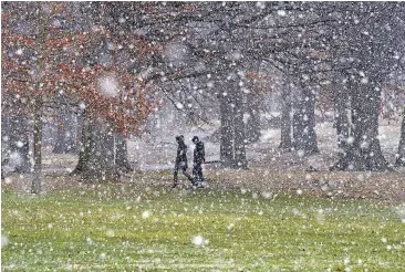  ?? SAPP, PITTSBURGH POST-GAZETTE VIA AP] [PHOTO BY DARRELL ?? People cross Flagstaff Hill as the snow starts to fall, in Schenley Park, on their way to the Carnegie Mellon University campus on Tuesday in Pittsburgh. Yet another powerful storm bore down on the Northeast on Tuesday.