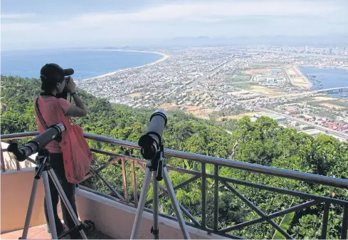  ??  ?? A visitor takes photograph­s from a viewpoint above Danang, the Vietnamese coastal city that marks the eastern terminus of the East-West Economic Corridor.