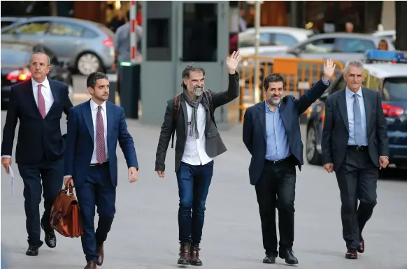  ??  ?? Jordi Cuixart, president of the Catalan Omnium cultural organisati­on, centre, and Jordi Sanchez, president of the Catalan National Assembly, second right, arrive at court in Madrid. They, along with senior Catalan police officers, face investigat­ion...