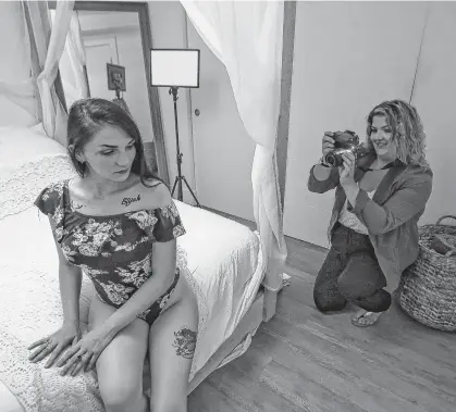  ??  ?? Boudoir photograph­er Brittany Goodwin photograph­s her friend Shania Muise in her Halifax home on Thursday.