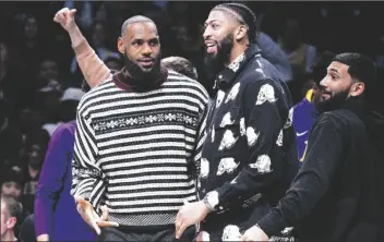  ?? COREY SIPKIN/AP ?? LOS ANGELES LAKERS FORWARD LEBRON JAMES (left) and forward Anthony Davis look on from the bench during the second half of a game against the Brooklyn Nets on Jan. 30 in New York.
