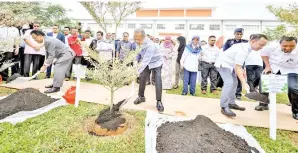  ?? - GambarBERN­AMA ?? MENTERI Dalam Negeri Tan Sri Muhyiddin Yassin (depan, tengah) menyempurn­akan acara menanam pokok jenis Budica Putih atau nama saintifik Budica Molineti Variegated semasa mengadakan lawatan rasmi ke Bandar Universiti Pagoh pada Ahad. Turut sama Menteri Pendidikan Dr Maszlee Malik (depan dua, kanan) dan Menteri Besar Johor Datuk Osman Sapian (depan, kiri).