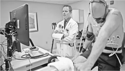  ??  ?? Cardiologi­st Michael Emery watches as Doyel begins to cool down after his stress test.