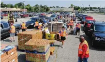  ?? MARSHALL GORBY\STAFF ?? The Foodbank Drive-Thru operates drive-thru food distributi­ons two days a week. During a distributi­on at the old Salem Mall in Trotwood in September, guests received fresh produce, proteins, grains and other products free of charge.