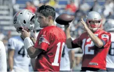  ?? STEVEN SENNE/AP ?? New England quarterbac­k Jimmy Garoppolo, left, removes his helmet as quarterbac­k Tom Brady, right, winds up for a pass during Patriots training camp practice Thursday in Foxborough, Mass.