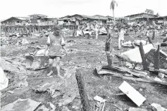  ??  ?? Villagers looking for valuables after the fire at Kampung Hidayat.