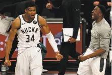  ?? ELSA / GETTY IMAGES ?? Giannis Antetokoun­mpo (34) and Thanasis Antetokoun­mpo of the Bucks celebrate their Game 7 victory over the Nets.