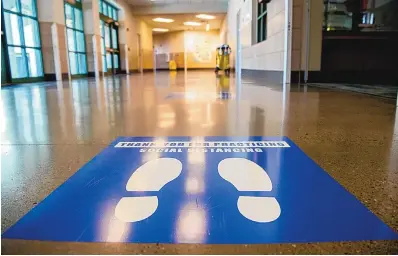  ?? EDDIE MOORE/JOURNAL ?? Markers on the floor at El Camino Real Academy in Santa Fe in October remind students to keep their distance from others to limit the spread of COVID-19.