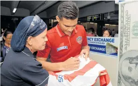  ?? JOSEFINA VILLARREAL ?? Teó Gutiérrez firma una camiseta del Junior, luego de su arribo a Barranquil­la.