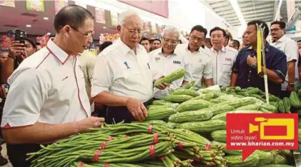  ?? [FOTO MUHAMMAD ASYRAF SAWAL/BH] ?? Najib diiringi Hamzah melihat sayur-sayuran selepas melancarka­n KR1M 2.0 di Pasar Raya TMG, di Temerloh, semalam.