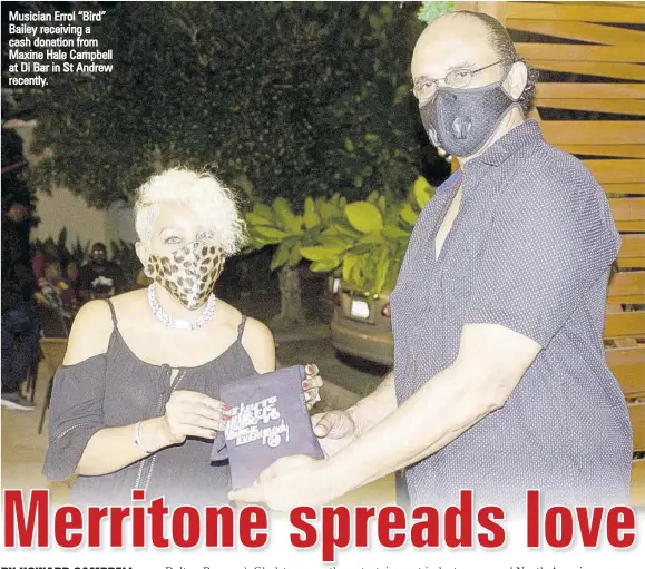  ??  ?? Musician Errol “Bird” Bailey receiving a cash donation from Maxine Hale Campbell at Di Bar in St Andrew recently.