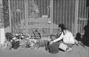  ?? JAE C. HONG/AP PHOTO ?? A woman comforts her son Monday while visiting a makeshift memorial outside Star Dance Studio in Monterey Park, Calif. Authoritie­s searched for a motive for the gunman who killed 11 people at the ballroom dance club during Lunar New Year celebratio­ns.