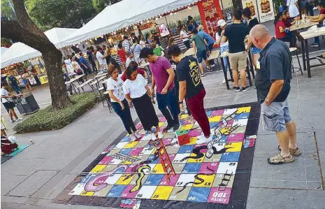  ??  ?? Makati Street Meet: Snakes and Ladders are a great way to make new friends at weekend hubs.