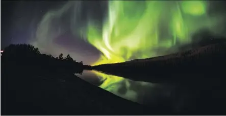  ?? ROBERT MURRAY ?? The northern lights shine and reflect on the Clearwater River in Fort McMurray. An expert at the University of Alberta is working to understand how space storms work.