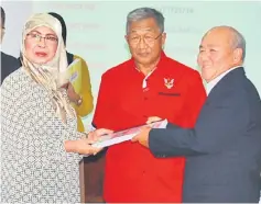  ??  ?? Rodziah (left) and Tang exchange the contract documents as Muhamad Yakup looks on.