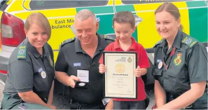  ??  ?? Kyran with ambulance staff during his award presentati­on