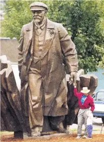  ?? ROBERT SORBO/ASSOCIATED PRESS FILE PHOTO ?? A 16-foot-high bronze statue of former Soviet leader Vladimir Lenin, above in 1995 with visitors, is facing calls for its removal after deadly violence in Charlottes­ville, Va., last weekend.