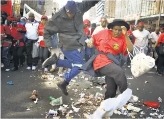  ?? The Times. ?? Take it easy: Johannesbu­rg municipal workers trash the streets of the inner city during a strike. Now a labour court ruling has been seen as confirmati­on that employers may seek urgent relief in disputes when unions breach the rules of picketing. /©