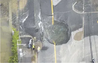  ??  ?? Water flows out from cracks on a road damaged by the earthquake in the city of Takatsuki in Osaka province in this photo taken by Kyodo yesterday.