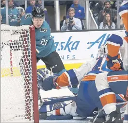  ?? JEFF CHIU — THE ASSOCIATED PRESS ?? Sharks right wing Timo Meier, left, sneaks the puck past New York Islanders goaltender Robin Lehner during the first period of Saturday night’s win in San Jose.
