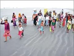  ?? DIBYANGSHU SARKAR/AFP ?? Rohingya refugees walk towards refugee camps after landing at the Saplapur beach in Bangladesh’s Teknaf district.