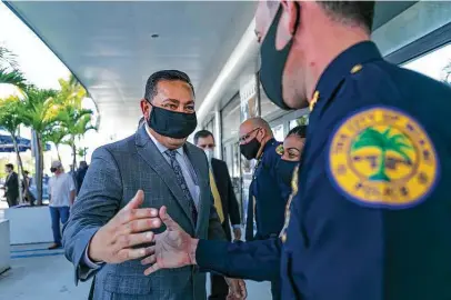  ?? Matias J. Ocner / Miami Herald ?? Outgoing HPD Chief Art Acevedo greets officer Armando Aguilar Jr. after a news conference at Miami City Hall on Monday.