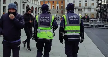  ?? ?? Due agenti della polizia locale di Brescia durante un controllo di piazza Vittoria, ritrovo di molti giovanissi­mi