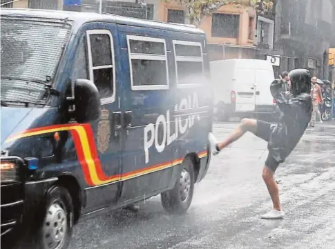  ?? JAIME GARCÍA ?? Un hombre patea un furgón de la Policía Nacional durante la consulta ilegal del 1-O