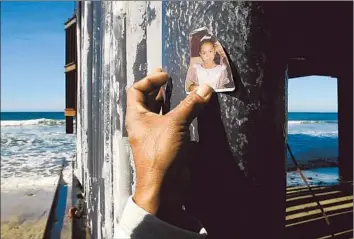  ?? Photog raphs by Don Bartletti Los Angeles Times ?? ON THE TIJUANA SIDE of the border fence, Luis Ernesto Rodriguez, 43, holds up a tattered photo of one of his girls. He was here when one of his attorneys delivered news about his fight to be reunited with them.