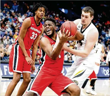  ?? ANDY LYONS / GETTY IMAGES ?? Georgia’s Yante Maten grapples with Missouri’s Reed Nikko for a rebound Thursday during the Bulldogs’ improbable 62-60 second-round win at the SEC Tournament at Scottrade Center in St Louis.