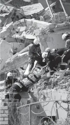  ?? FOTO: AFP ?? Rescatista­s evacúan el cuerpo de una persona desde el edificio destruido por misiles rusos.