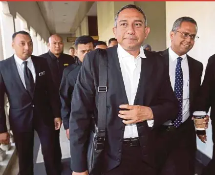  ?? SAALI PIC BY MOHAMAD SHAHRIL BADRI ?? Datuk Mohd Hafarizam Harun (second from right) leaving the Kuala Lumpur Sessions Court yesterday after being charged with two counts of money laundering.