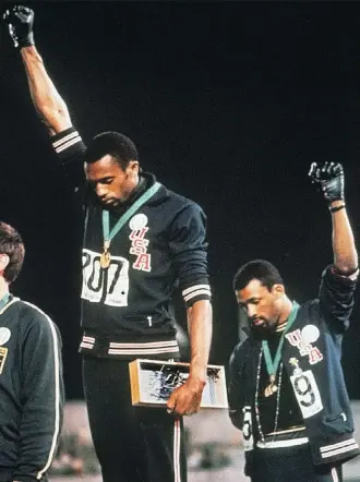  ?? THE ASSOCIATED PRESS/FILES ?? An enduring image from the 1968 Summer Olympics in Mexico was that of U.S. track stars Tommie Smith and John Carlos raising their fist in protest during the playing of The Star-Spangled Banner after Smith received the gold and Carlos the bronze medal...