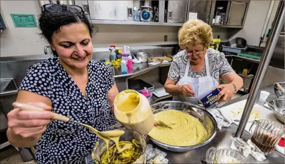  ?? Times Union archive ?? Parishione­rs of St. Peter Armenian Church prepare baba ghanoush for sale during a previous Armenian Festival in Watervliet. This year, the festival will be held Friday through Sunday, June 3-5 at the church, 100 Troy-schenectad­y Road. At right, one of the church’s stained-glass windows is shown.