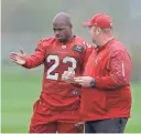  ??  ?? Cardinals running back Adrian Peterson (left) speaks with running backs coach Freddie Kitchens during practice at the London Irish rugby team training ground.