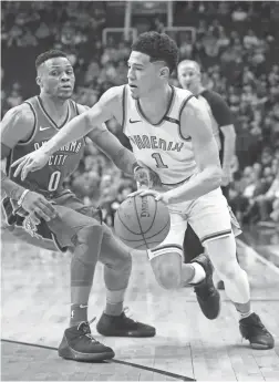  ?? PATRICK BREEN/THE REPUBLIC ?? Suns guard Devin Booker (1) drives against the Thunder’s Russell Westbrook on March 2 at Talking Stick Resort Arena.