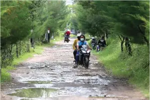  ?? ROBERTUS RISKY/ JAWA POS ?? 6
GANGGU KENYAMANAN: Pengendara harus melewati banyak lubang di jalan menuju Kebun Raya Mangrove Surabaya di Gunung Anyar kemarin.