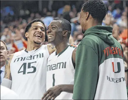  ?? CHUCK LIDDY / RALEIGH NEWS & OBSERVER ?? Miami’s Julian Gamble (45) and Durand Scott (1) celebrate as the Hurricanes beat N.C. State 81-71 on Saturday to advance to today’s match with North Carolina for the ACC title.