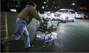  ?? JOHN MINCHILLO — THE ASSOCIATED PRESS ?? Customer Harry Westhoff, 71, runs his groceries back to his car after shopping at a Stop & Shop supermarke­t that opened special morning hours Friday to serve people 60-years and older due to coronaviru­s concerns, in Teaneck, N.J.