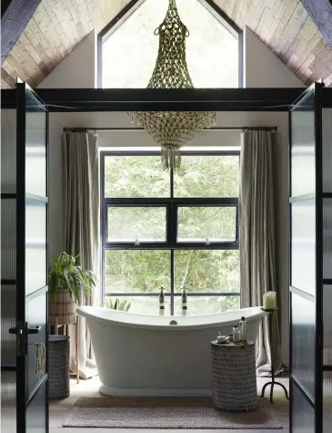  ??  ?? Opposite page: The vibrant green bathroom features tiles from Emery & Cie; basin, stand and taps all Drummonds.
This page: Freestandi­ng bath and taps by The Water Monopoly, rope pendant light from Abigail Ahern and stool from Bungalow Living Bali.