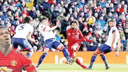  ??  ?? SALAH (dua kanan) melepaskan rembatan melepasi pemain Bournemout­h ketika beraksi pada perlawanan Liga Perdana Inggeris di Anfield, Liverpool pada Sabtu lepas. — Gambar AFP