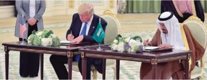  ??  ?? RIYADH: US President Trump signs cooperatio­n agreements with King Salman Bin AbdulAziz.